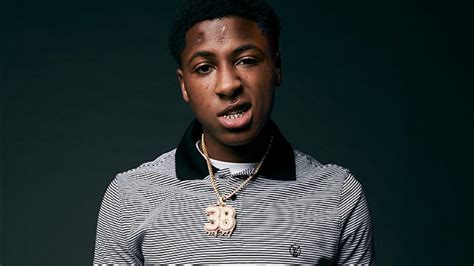 Nba Youngboy Is Wearing Black White Striped T Shirt In Green Background