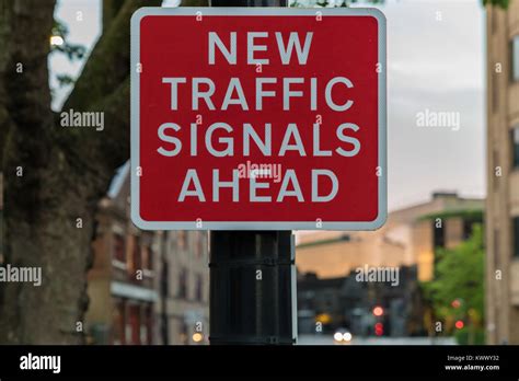 Sign New Traffic Signals Ahead With Some Blurry Traffic Signals In
