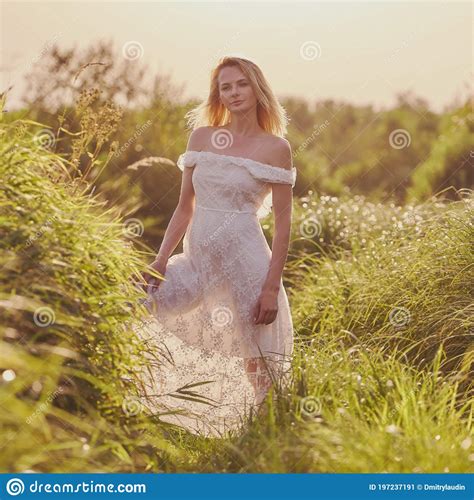 A Blonde Girl In A White Dress Walks Outdoors In The High Field Grass Stock Image Image Of