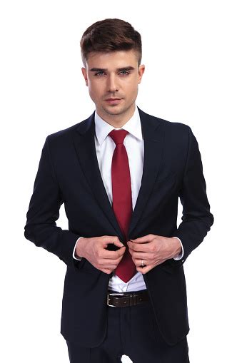 Portrait Of Handsome Businessman Buttoning His Navy Suit Jacket Stock