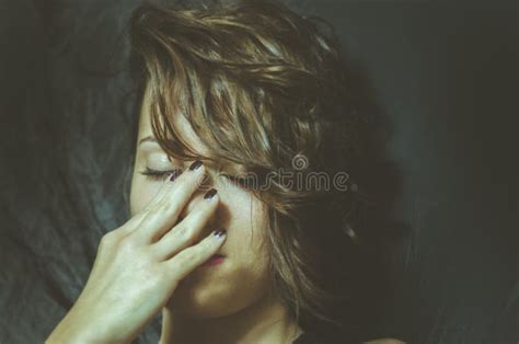 Young Depressed Woman Feeling Miserable And Lonely Cover Her Face With Her Hands In The Dark