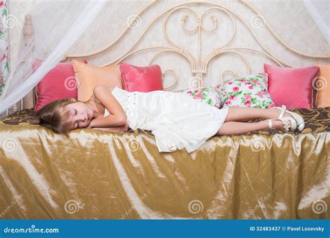kleines mädchen schlafend auf einem bett in der kleidung stockbild bild von ausdruck kinder