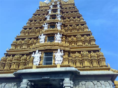 An Ornate Gold And White Building With Statues On It