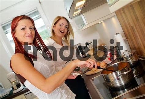 Two Young Women Cooking Together Download People