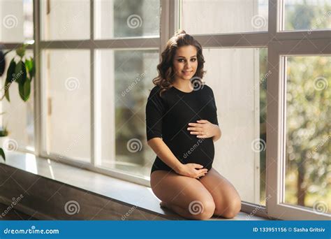 Pregnant Moman Sits Near The Big Window Model Dressed In Black