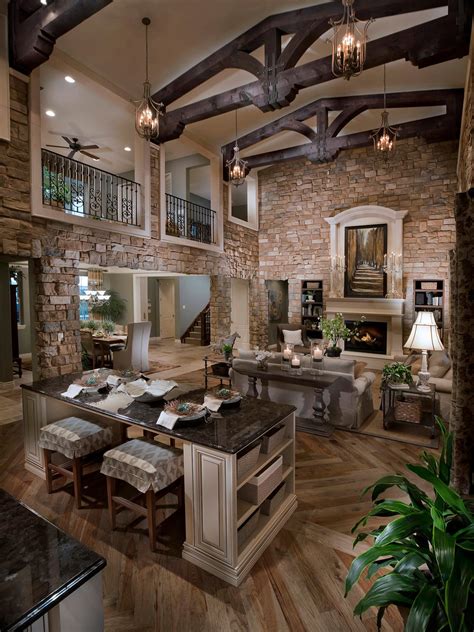 Open plan kitchen and living room with custom kitchen island that includes wine storage. Cathedral Great Room With Gorgeous Stone Walls | HGTV