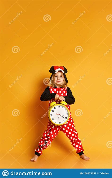 Little Happy Blond Girl In Red Dotted Pajamas Standing Holding Big