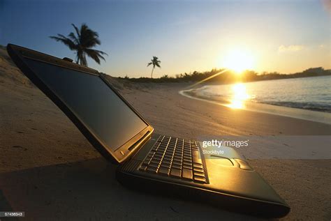 Side Profile Of A Laptop Computer Kept On The Beach At Dusk High Res