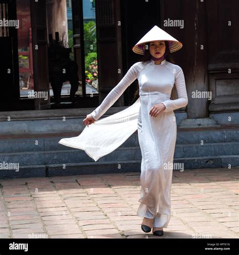 A Young Vietnamese Woman Wearing The Traditional Dress Ao Dai And The