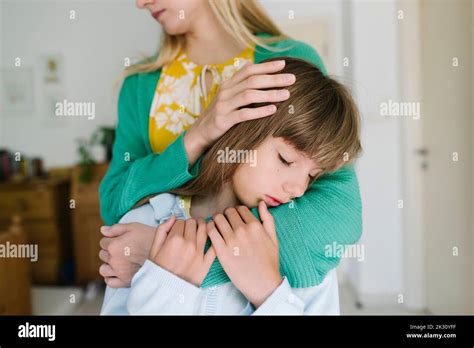 Mother Hugging Sad Daughter From Behind At Home Stock Photo Alamy