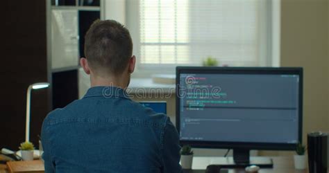 Young Man Freelancer Coding Html And Programming On Two Screen Monitors