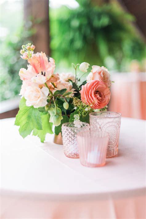 Two Vases Filled With Flowers Sitting On Top Of A White Table Covered