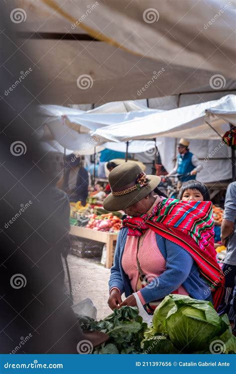 Peruvian Woman Carrying Her Child On The Back In Traditional Way Buying