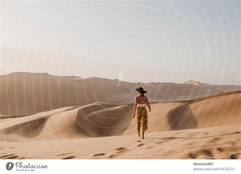 Namibia Namib Back View Of Woman Walking Barefoot On Desert Dune A Royalty Free Stock Photo