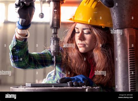 Portrait Of Pretty Girl At Work On Industrial Drilling Machine Stock