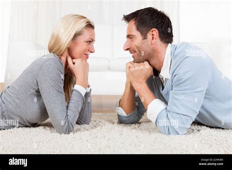 Young Couple Watching Each Other Gazing Into Each Others Eyes With Love While Lying On Their