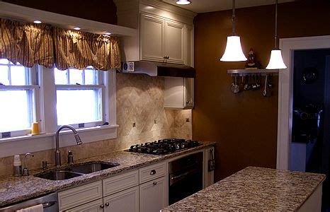 Painting kitchen cabinets rejuvenates your home. Ivory painted cabinets with Santa Cecilia granite | Oak ...