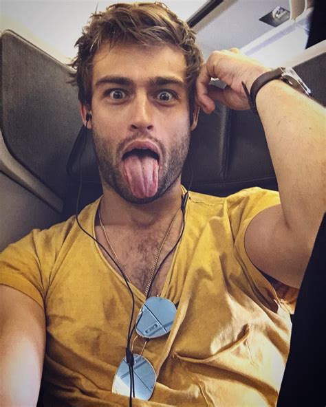 A Man Sticking His Tongue Out While Sitting In An Airplane With