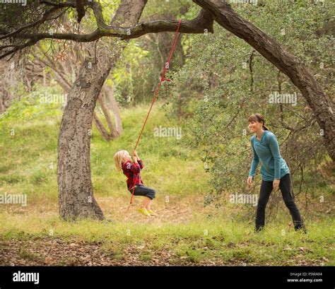 Mother Pushing Son On Tree Swing Stock Photo Alamy