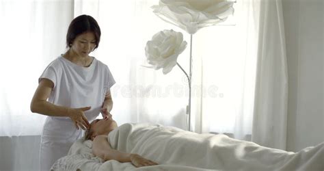 Asian Chiropractor Woman Is Performing Massage For Female Client In