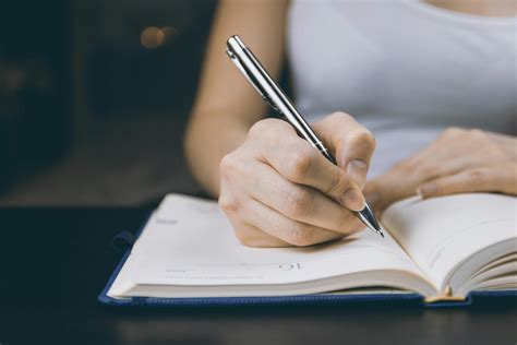 Photo Of Person Writing On Notebook · Free Stock Photo