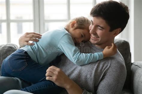 Affectionate Little Baby Girl Embracing Smiling Father Stock Image