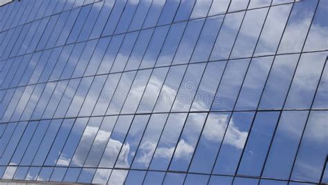 Reflection Of The Sky With Clouds In The Glass Windows Of The Building