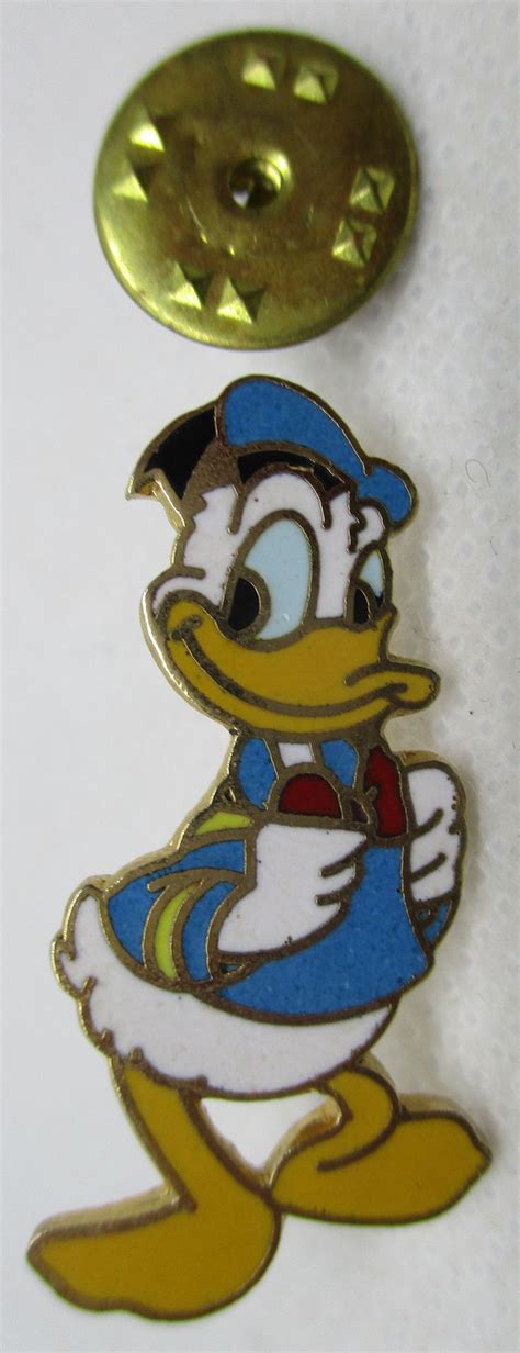 A Yellow And Blue Donald Ducky Pin Sitting On Top Of A White Table Next