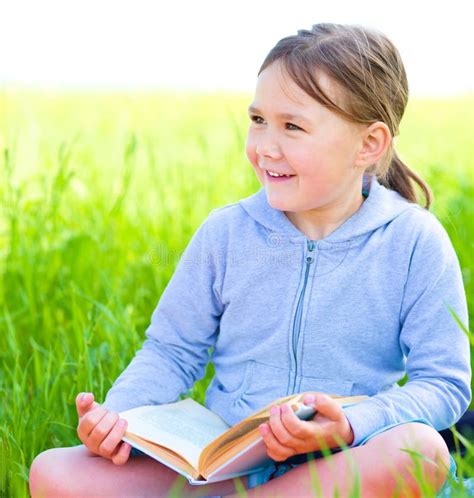 Little Girl Is Reading A Book Outdoors Stock Image Image Of Playful