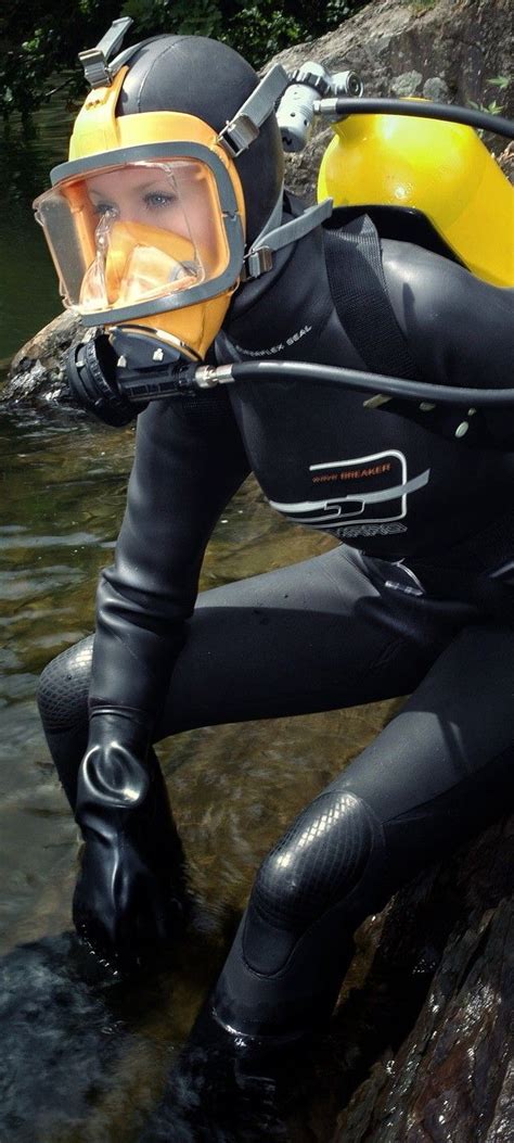 A Man In Black Wetsuit And Yellow Helmet Standing Next To A Body Of Water