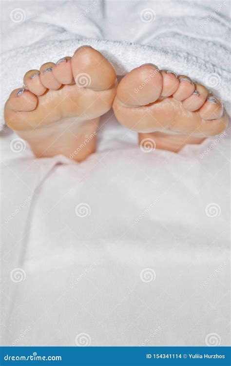 Les Pieds Nus Blancs De La Femme S Couverts De Serviette Blanche Mensonge Sur Le Divan Jetant