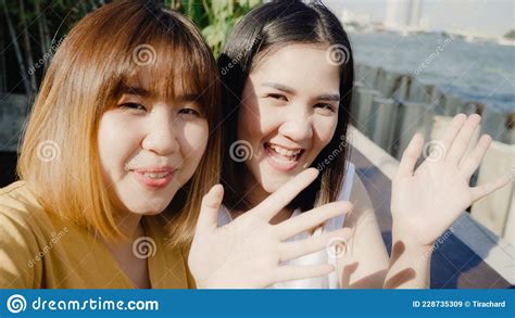 lesbian lgbtq women influencer couple waving hand making video call at cafe asian lover lady