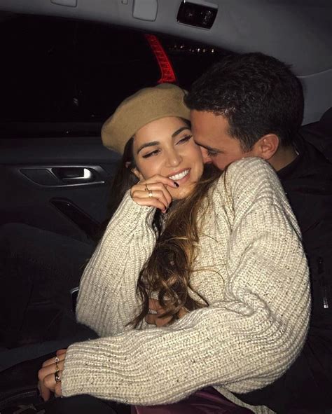 A Man And Woman Sitting In The Back Seat Of A Car Smiling At Each Other