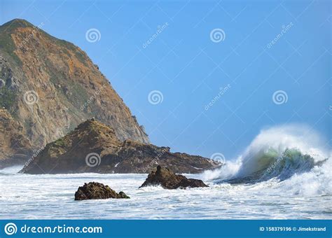 Large Wave Curls Towards A Rugged Coastline Stock Photo Image Of
