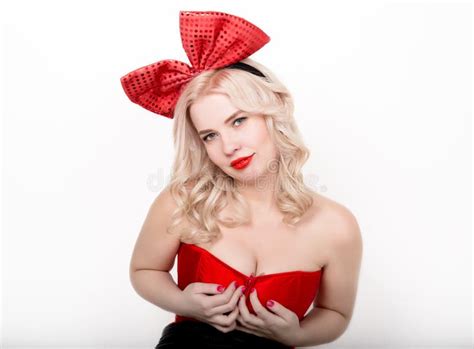 schöne sexy blondine mit den großen brüsten in einem roten korsett und in einem großen bogen