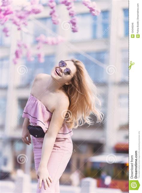 Beautiful Young Blonde Girl In Sunglasses With Puffy Lips And Feminine Body Posing On The Street