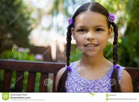 retrato do close up da menina de sorriso que senta se no banco foto de stock imagem de olhar