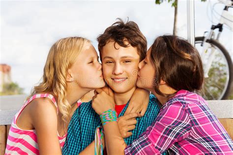 亲吻一个男孩的两个女孩获得室外的乐趣 库存图片 图片 包括有 亲吻一个男孩的两个女孩获得室外的乐趣 71019835
