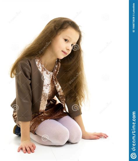 Beautiful Thoughtful Girl Sitting On The Floor On Her Knees Stock Photo