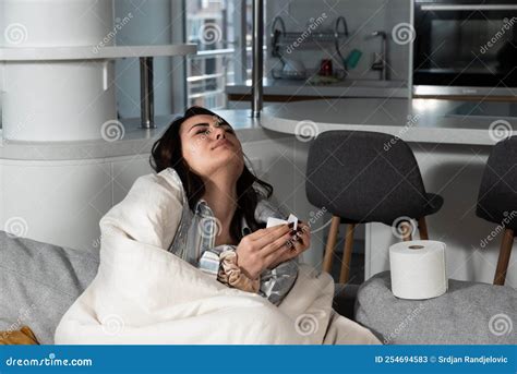 Young Sick Stressed Woman Lying At Home Covered With Blanket Blowing