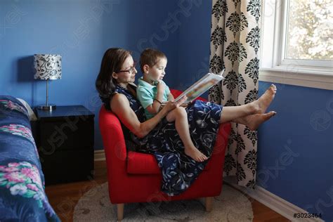 Mother With Son Boy Sitting In Armchair At Home And Stock Photo