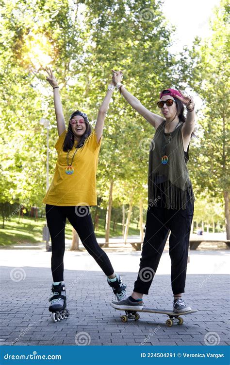 Happy Girls Shaking Hands And Posing With Roller Skates Stock Image