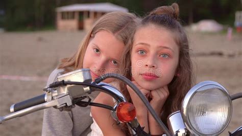 Two Sisters Have Fun Together Two Girls Pose On The Beach At The White Moped Stock Footage