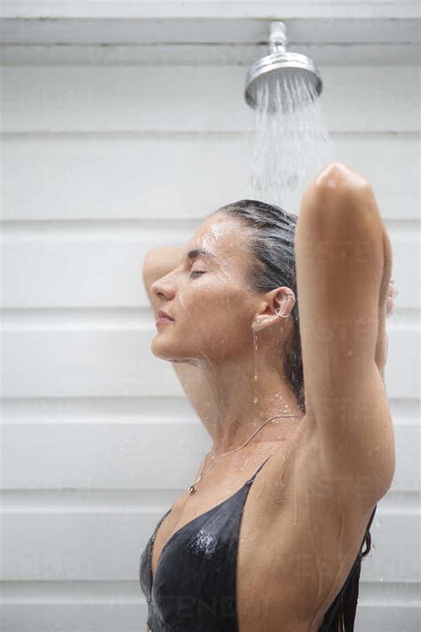 Side View Of Woman Taking Shower Stock Photo