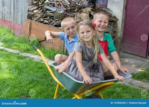 Children Sitting In A Wheelbarrowhappy Children Sitting In A