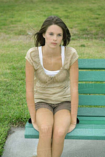 Teenage Girl Sitting On Bench Looking Away Stock Photo Dissolve