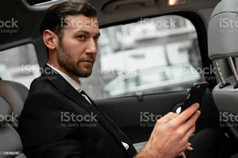 Handsome Businessman Sitting On The Backseat Of The Car Stock Photo