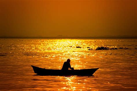 Evening Golden Sunset Time A Fisherman Fishing On The Seaside On A