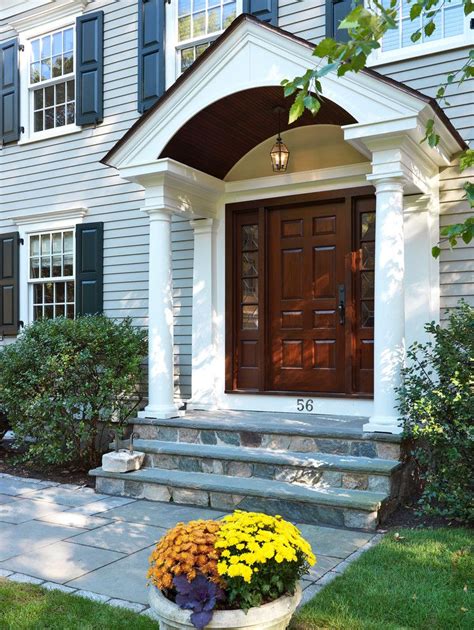 Brown Wooden Colonial Front Door With Beautiful Portico With Stones