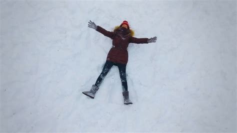 Slow Motion Young Woman Making Snow Angels Stock Footage
